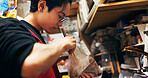 Japanese chef man, chopsticks and kitchen with plastic, search bag and thinking with stirring for cooking. Person, restaurant worker or catering service with cuisine, meal prep and nutrition in Tokyo