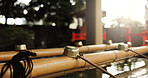 Shinto temple, closeup and fountain with water in container for faith, clean or washing hands for wellness. Religion, mindfulness or praise with purification ritual in woods, peace or shrine in Kyoto