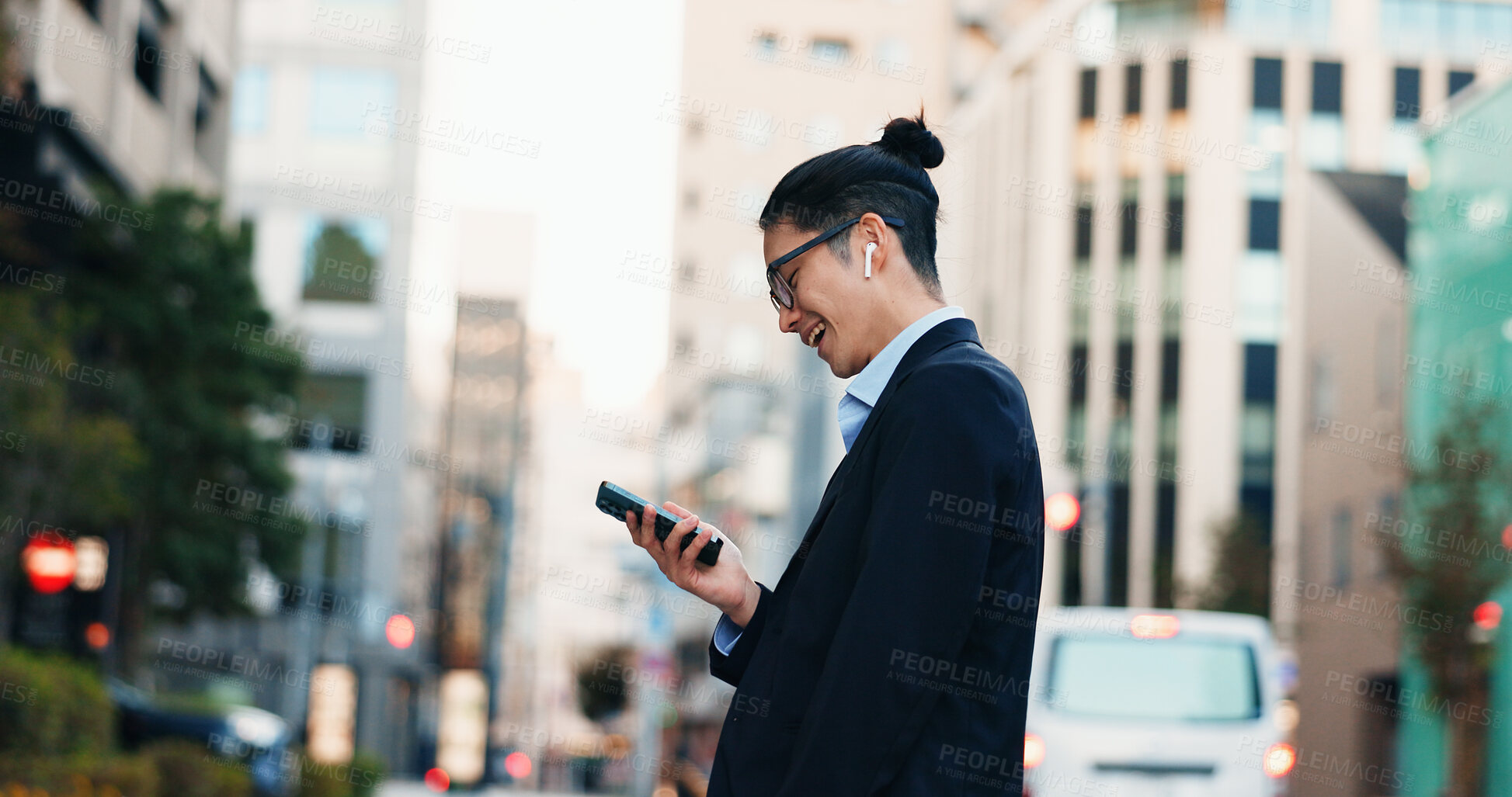 Buy stock photo Cellphone, networking and Japanese businessman in city reading company email on technology. Career, travel and professional young male person scroll or browse on a phone with earbuds in urban town.