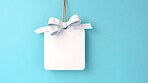 Card, gift and paper sign with bow on blue background for copy space announcement, invitation message or offer. Bow, ribbon, white coupon for discount, sale, special surprise voucher.