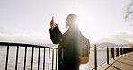 Japanese woman, lake and phone for photography, memory and post on web blog for travel with backpack. Girl, person and outdoor with smartphone by water, river and photoshoot for social media in Tokyo