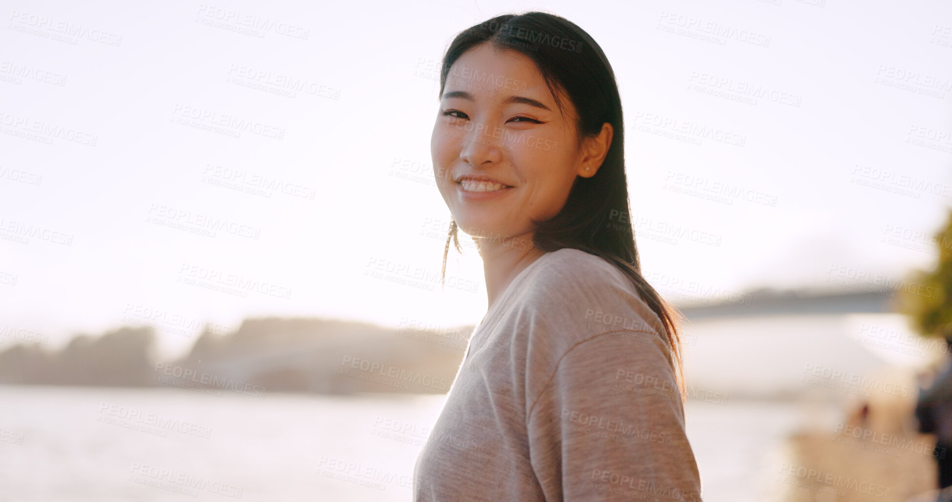 Buy stock photo Japanese woman, happiness and sunshine outdoor, lake or river with travel, holiday and positivity in nature. Wellness, adventure and care free in park in Japan, smile with lens flare and portrait