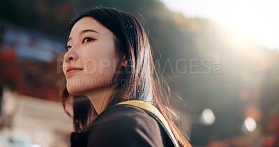Japanese woman, street and backpack on walk, thinking or lens flare on adventure, trip or vacation. Girl, person and direction on holiday with bag, vision or memory on road, city or sidewalk in Tokyo