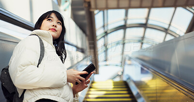 Woman, stairs and smartphone for commute, texting and japanese on social media app. Technology, communication and text message for digital, internet and chatting with backpack, travel and escaltor