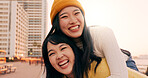 Friends, women and piggyback outdoor on promenade with bonding, laughing and adventure on holiday or vacation. Travel, Japanese people or embrace at beach in city with fun, comedy or freedom together