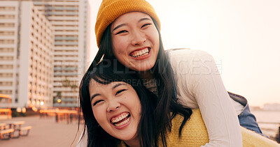 Friends, women and piggyback outdoor on promenade with bonding, laughing and adventure on holiday or vacation. Travel, Japanese people or embrace at beach in city with fun, comedy or freedom together