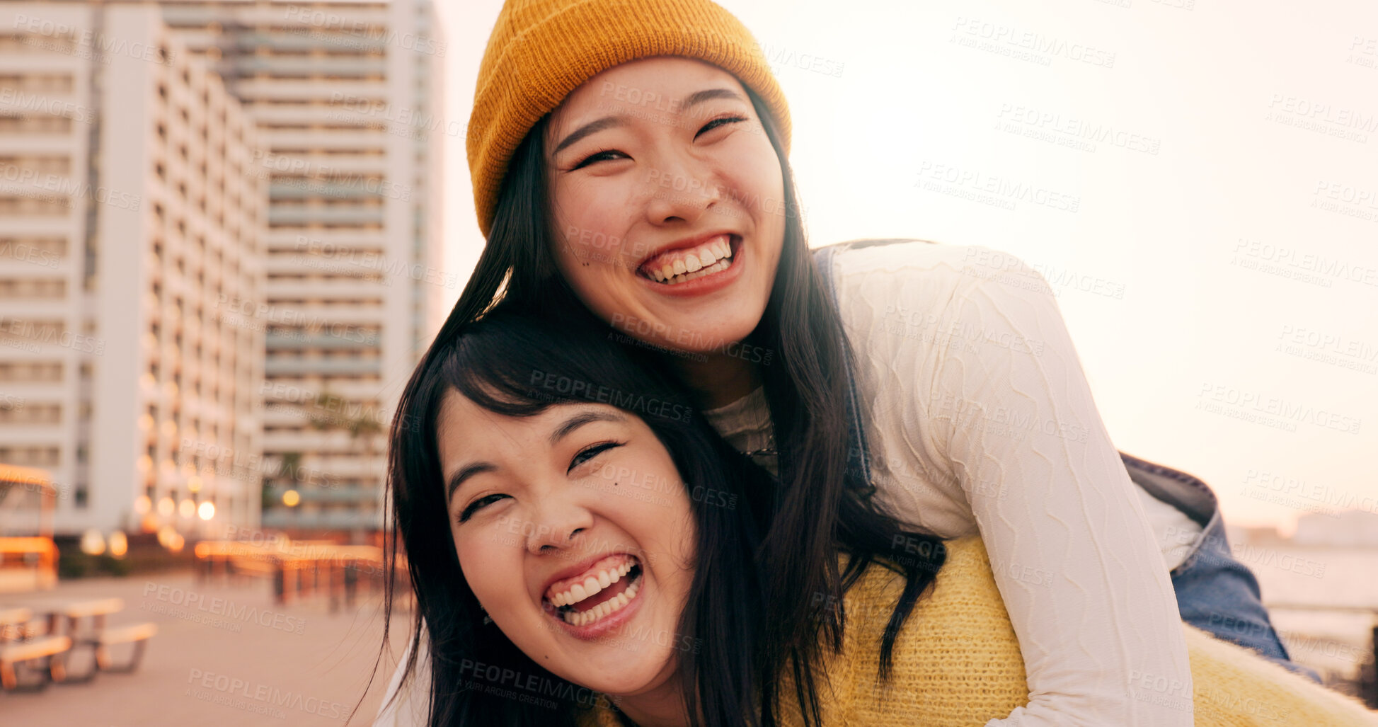 Buy stock photo Friends, women and piggyback outdoor on promenade with bonding, laughing and adventure on holiday or vacation. Travel, Japanese people or embrace at beach in city with fun, comedy or freedom together