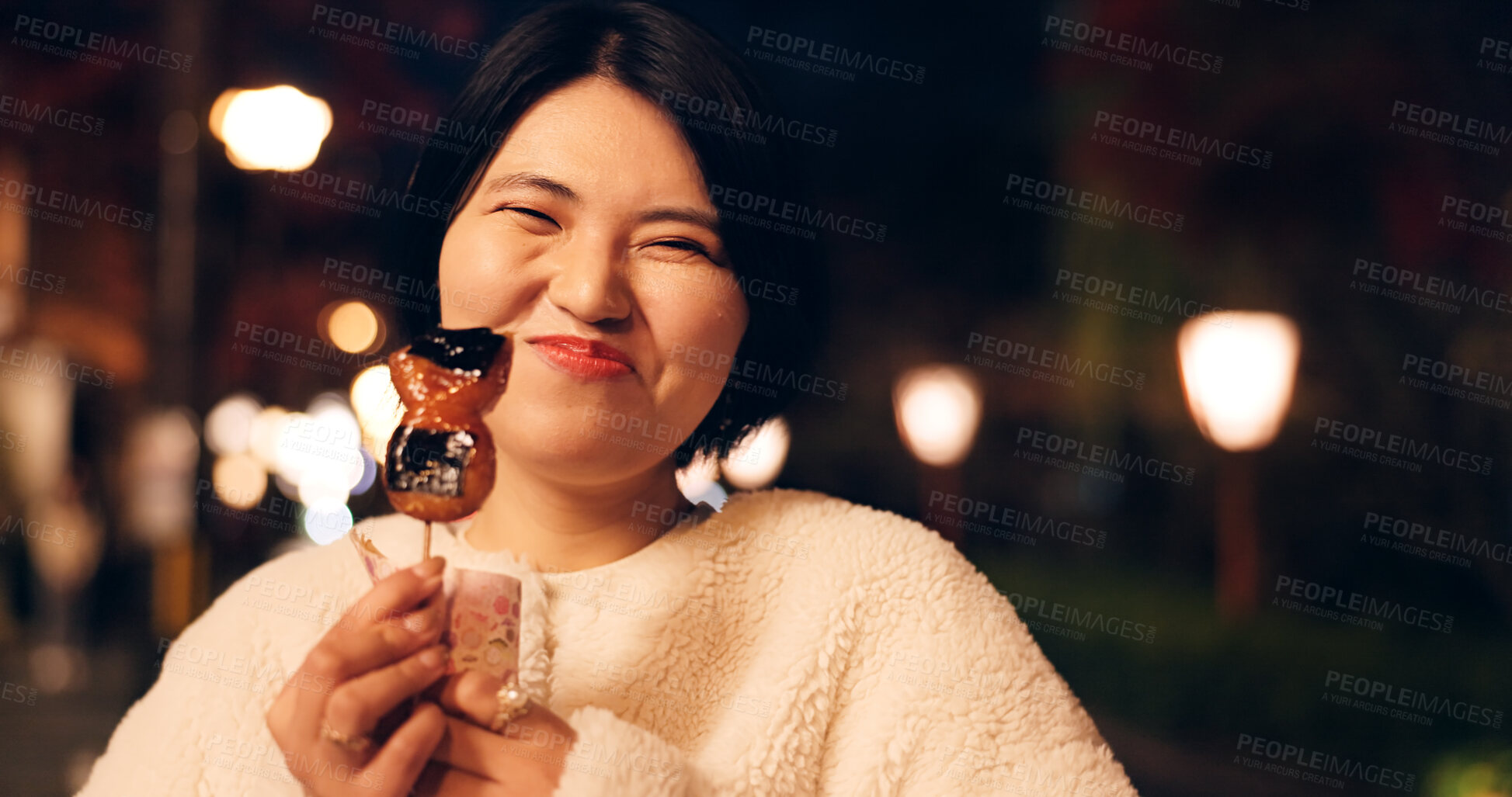 Buy stock photo Woman, street food and eating Japanese snack for tourist experience, hungry or local. Female person, face and sidewalk at night for mochi candy for city vacation or culture, adventure or tradition