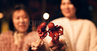 Women, Japan and travel street food at night for octopus delicacy, culture or traditional. Female people, snack and stick for tourism eating experience or cuisine in town for taste, dinner or holiday