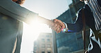 Outdoor, business people and professional with handshake, conversation and contract with lens flare, corporate and talk. Staff, employees in a city and coworkers with hello, partnership or urban town