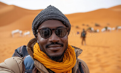 African man, desert and background with glasses for travel, freedom or vacation. Health, activity and outdoors with selfie theme and sunset view for wellness, motivation or discovery in nature