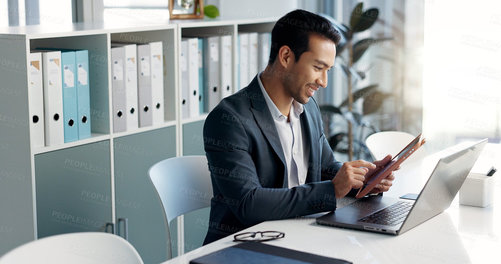 Buy stock photo Happy business man, laptop and tablet for data analytics, stock market and online research for profit, sales or company account. Asian trader, investor or analyst in office on digital tech and computer