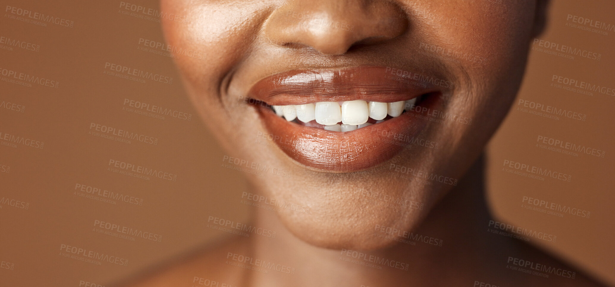 Buy stock photo Closeup, lips and black woman with beauty, smile and skincare on a brown studio background. African person, girl and model with gloss, cosmetics and dermatology with clear skin, smooth and aesthetic