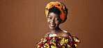 Wrap, fashion or face of happy black woman in studio on a brown background for trendy style. Smile, African or model with confidence, pride or afro posing in culture, clothes or traditional outfit