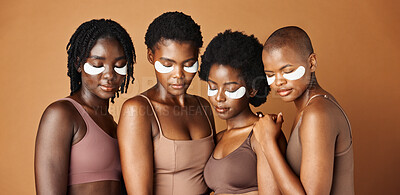 Happy black woman, eye patches and skincare for beauty, epilation or anti aging against a brown studio background. Group portrait of African female people or model in dermatology, health and wellness