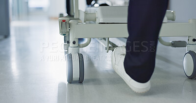 Healthcare, doctor and push bed in hospital for surgery, emergency or medical problem in corridor. Medicine, professional and nurse feet with stretcher for wellness, service and risk in clinic or job