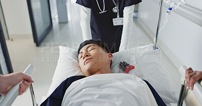 Asian man, patient and push bed in hospital for surgery, emergency or medical problem in corridor. Medicine, professional or person with stretcher for wellness, service and risk in clinic or job