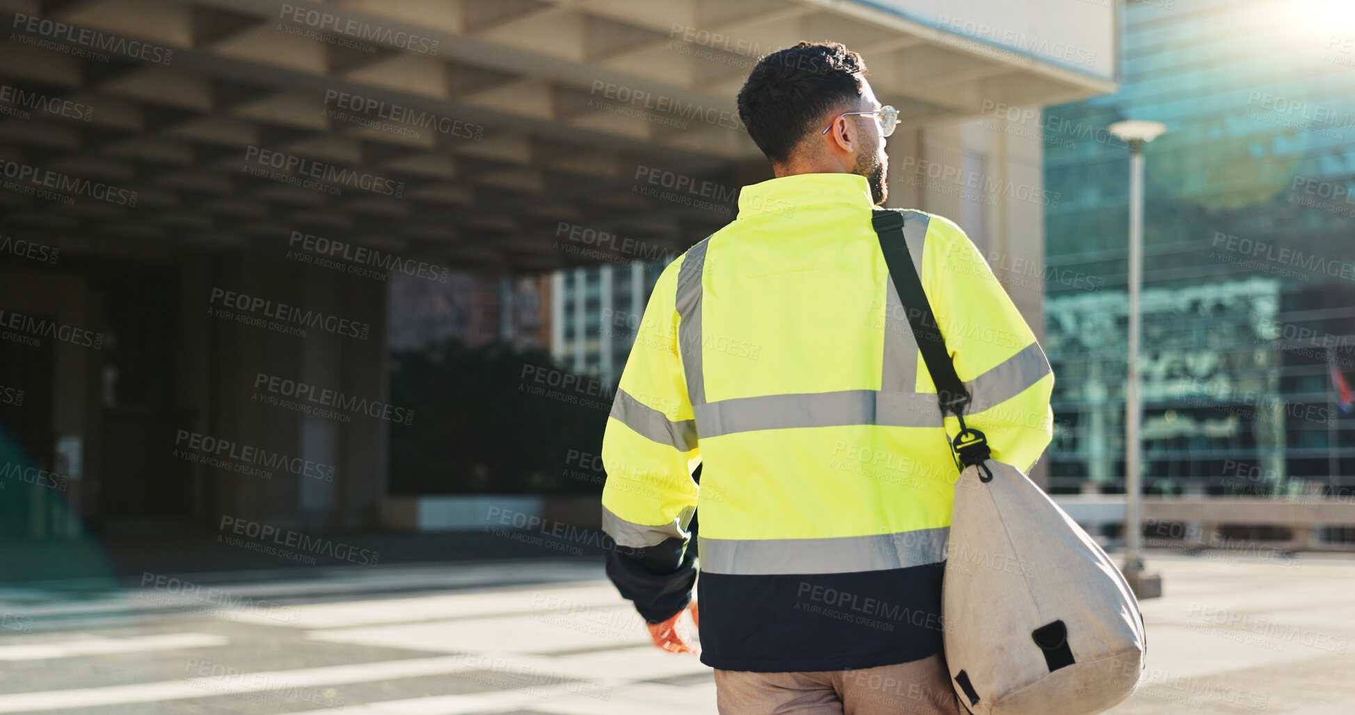 Buy stock photo Man, back and architect walking in city for construction, maintenance or building at outdoor site. Rear view of male person, engineer or contractor carrying bag for project, architecture or plan