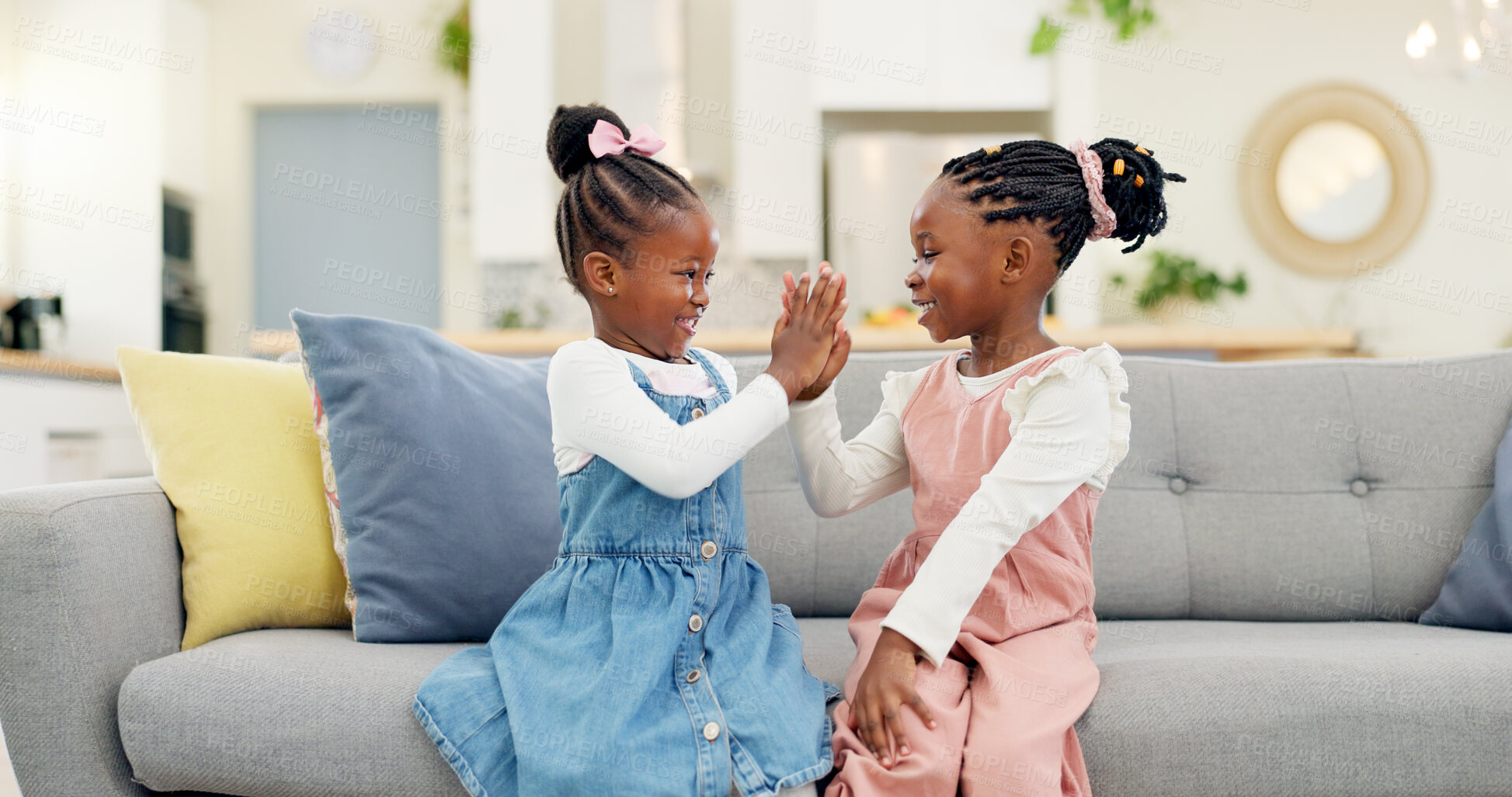 Buy stock photo Kids, high five and couch in a home with young, smile and happy from sibling bonding together. House, lounge sofa and daughter friends with talk and girl friendship with fun and youth in living room