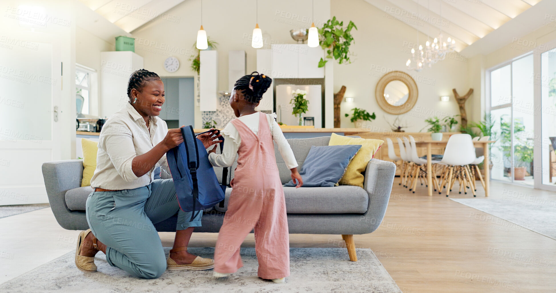 Buy stock photo Talking, happy and a mother with a child getting ready for school in the morning. Kiss, laughing and an African mom helping a little girl with a bag in the living room of a house for kindergarten