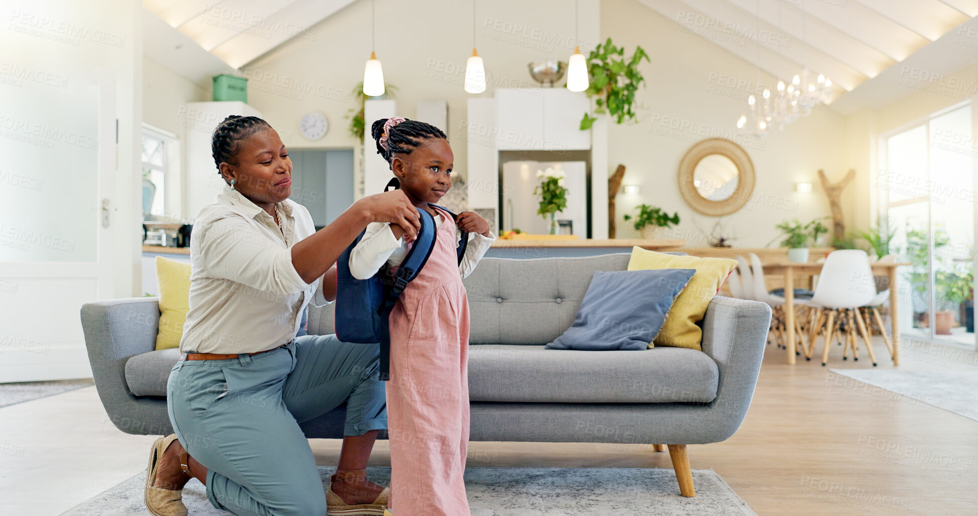 Buy stock photo Talking, happy and a mother with a child getting ready for school in the morning. Kiss, laughing and an African mom helping a little girl with a bag in the living room of a house for kindergarten