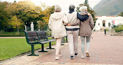Senior friends, talking and walking together on an outdoor path to relax in nature with elderly women in retirement. Happy, people pointing and conversation in the park or woods in autumn or winter