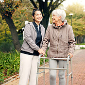 Senior woman, walker and nurse outdoor in a park with healthcare for ...