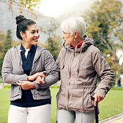 Senior woman, walker and nurse talking in a park with healthcare for ...