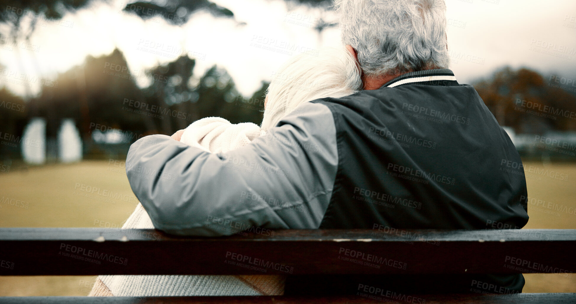 Buy stock photo Hug, senior couple and bench with back for retirement or to relax with care or quality time. Happy face, nature and elderly woman or man with support or embrace for love, trust in garden together.