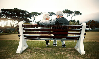 Buy stock photo Hug, bench or old couple in park or nature talking or bonding together in retirement outdoors back view. Senior, elderly man or mature woman on date to relax with love, peace or care on calm holiday
