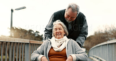 Senior couple, nature and in a wheelchair on a walk for happiness, retirement date or love. Smile, talking and an elderly man and woman with a disability and in a park to relax together in marriage