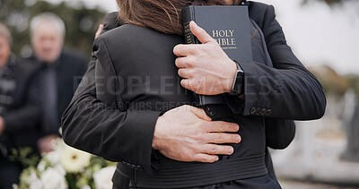 Funeral, graveyard and people hug for comfort, empathy and support at memorial service in cemetery. Depression, grief and sad man and woman for goodbye, mourning and burial for death with bible