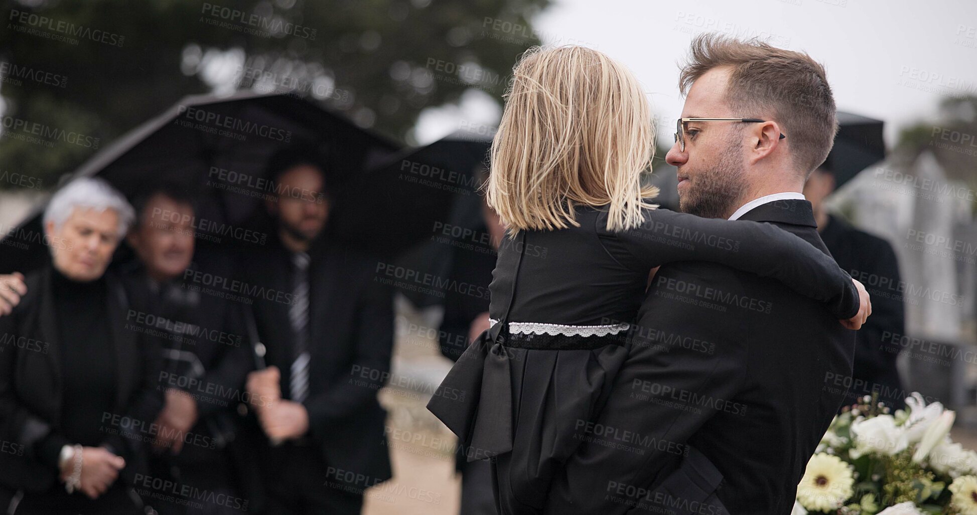 Buy stock photo Sad, hug and a father and child at a grave for a funeral and mourning with a group of people. Holding, young and a dad with care and love for a girl kid at a cemetery burial and grieving together