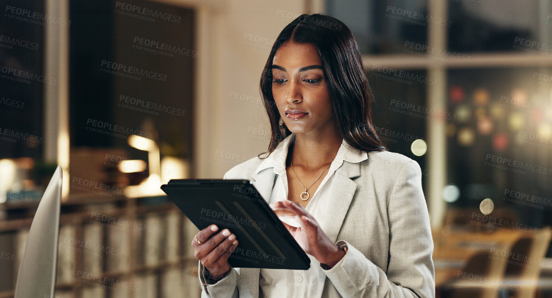 Buy stock photo Night, tablet and business woman typing, scroll and manager review journalist story, social media blog and working late. Professional news reporter, reading and Indian person check online article