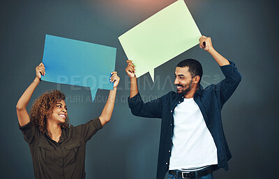 Buy stock photo Studio shot of a young couple holding speech bubbles against a gray background