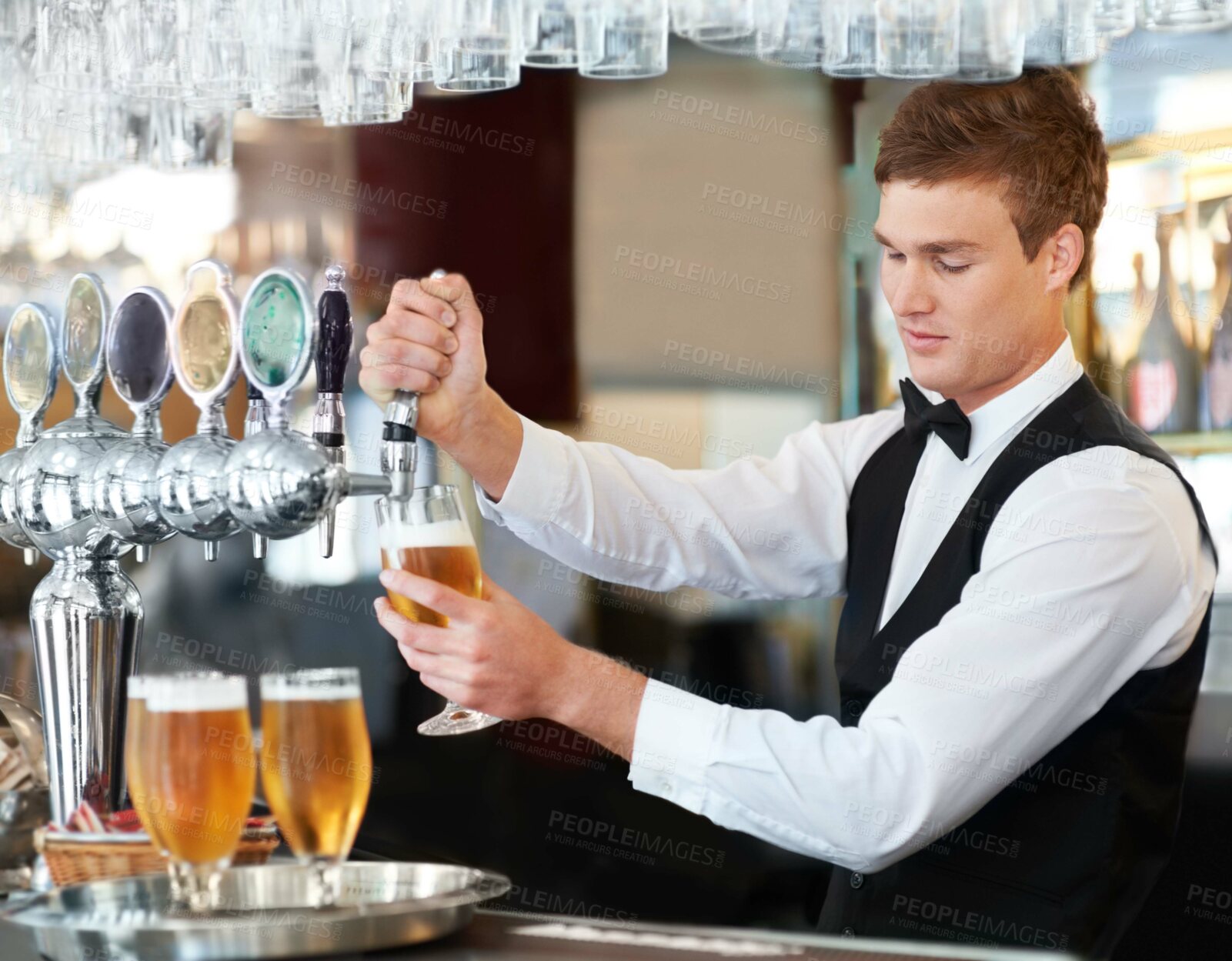 Buy stock photo Man, bartender and waiter with beer at pub, restaurant or event for happy hour, hospitality industry or customer service. Young barman, server or catering employee with alcohol drinks in glasses
