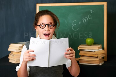 Buy stock photo A cute brunette girl looking fascinated by the book she is holding