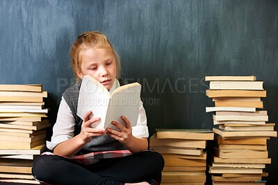 Buy stock photo Girl, classroom and child reading book for education, language learning and knowledge on chalkboard background. Kid or student on floor with books, library and story for school, English or literature