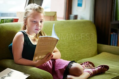 Buy stock photo Kid, girl on sofa and reading book for home learning, education and story with knowledge or creative mind. Child relax on couch with literature, English language and library novel in living room