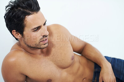 Buy stock photo Handsome man, relax and lying shirtless with denim jeans isolated against a white studio background. Face of calm, young or attractive sexy male person or model relaxing or leaning on wall in morning