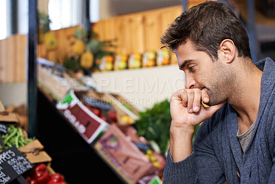 Buy stock photo Thinking, food and man shopping at a supermarket for grocery promotions, sale or discounts deal. Inflation, cost or customer buying groceries for nutrition, organic vegetables or diet choice in store