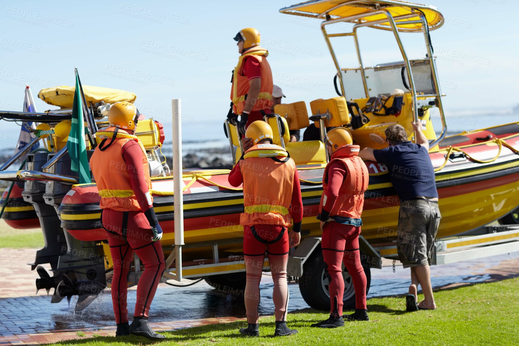 Buy stock photo Full length shot of a group of lifeguards preparing to go out to sea on a rescue mission