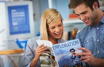 Buy stock photo Shot of a young couple looking at a travel brochure