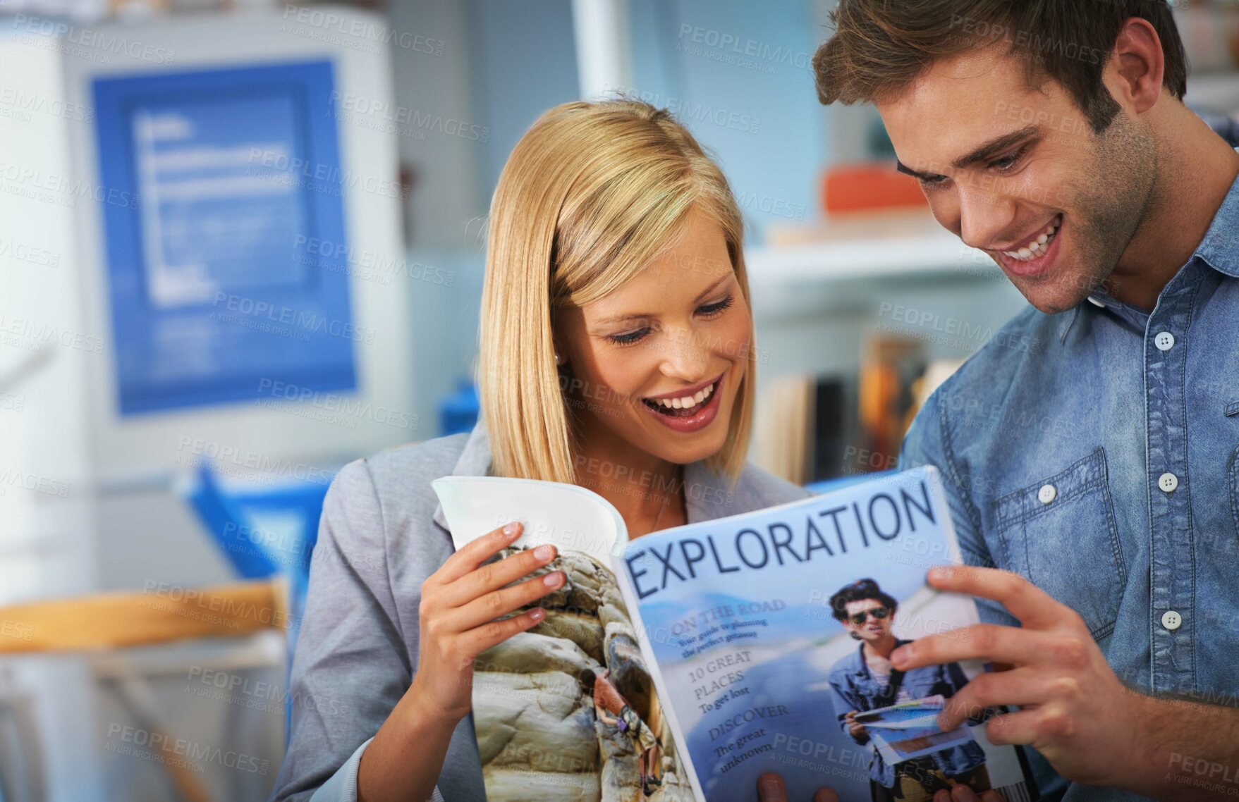 Buy stock photo Shot of a young couple looking at a travel brochure