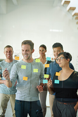 Buy stock photo Confident manager, leader or boss talking in a meeting, workshop or presentation with sticky notes in the boardroom. Businessman talking, discussing and brainstorming with a group of colleagues 