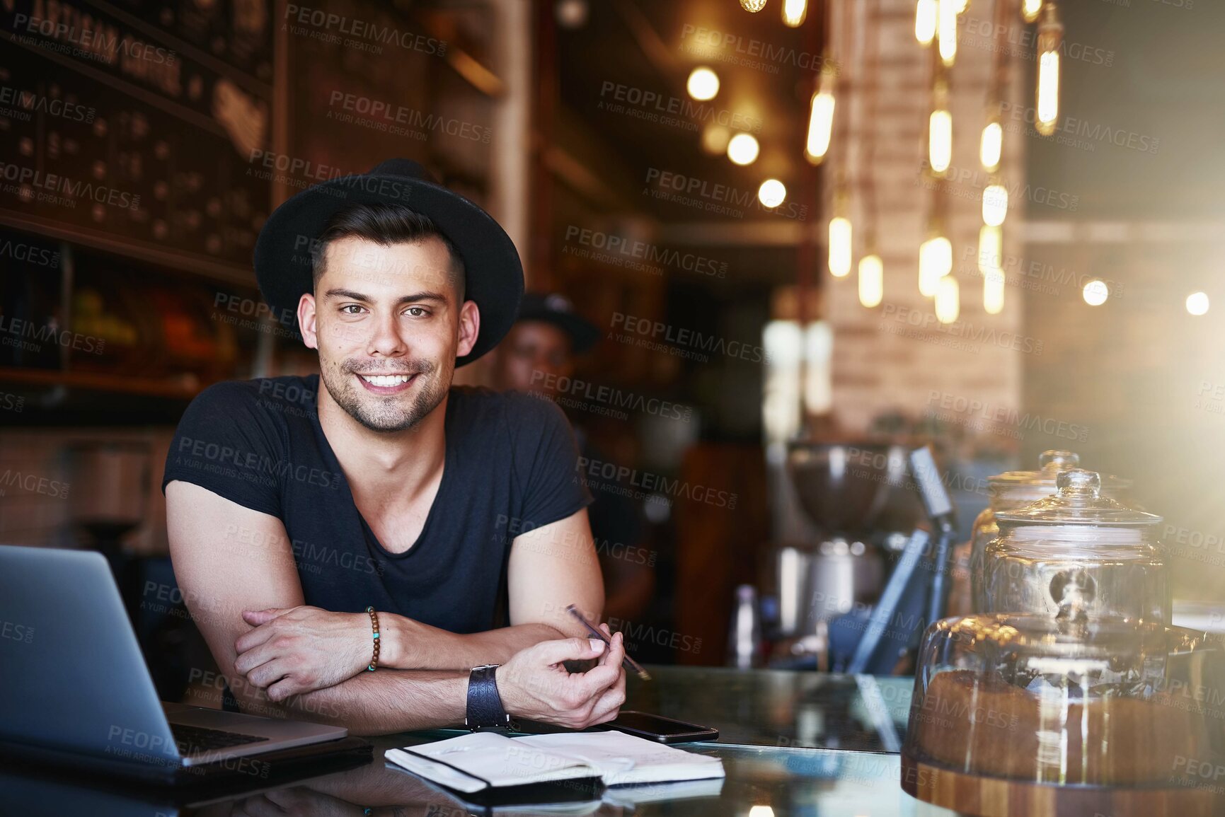 Buy stock photo Shot of a handsome young man working behind the counter of a coffee shop