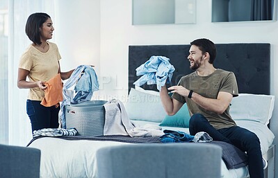 Buy stock photo Shot of a young couple doing laundry together at home