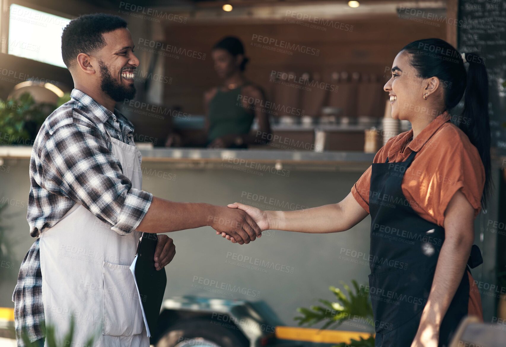 Buy stock photo Shot of two young restaurant owners standing outside together and shaking hands