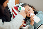 Thermometer, health and mother by sick girl laying in bed at home for influenza, fever or common cold. Disease, baby bottle and parent taking care of child with virus, illness and support in bedroom.