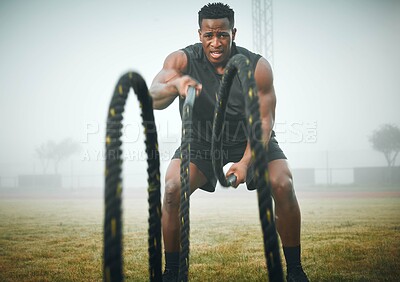Buy stock photo Fitness, battle rope and black man on field for power workout, body building and training muscle strength. Exercise, sports and African bodybuilder on grass with ropes, energy and outdoor performance